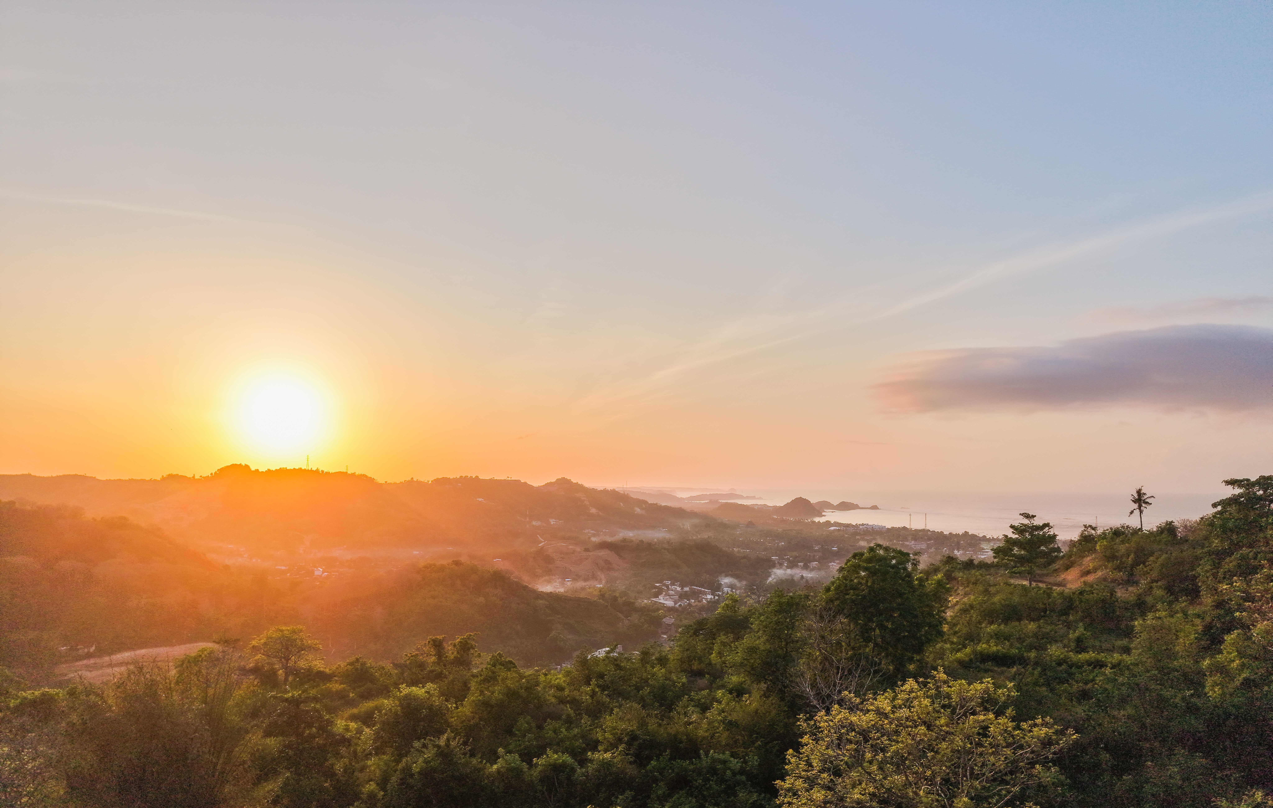 Two women sitting at a modern table talking with a city view behind them.